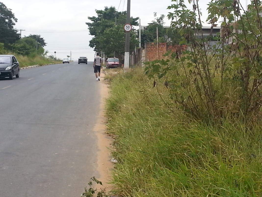 Mato invade calçada e obriga pedestres a andar no meio da rua no Satélite Íris