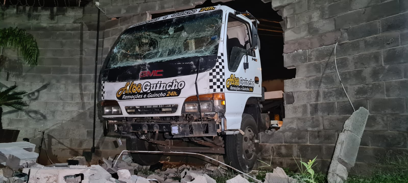 Caminhão-guincho perde os freios, bate em muro e invade barracão